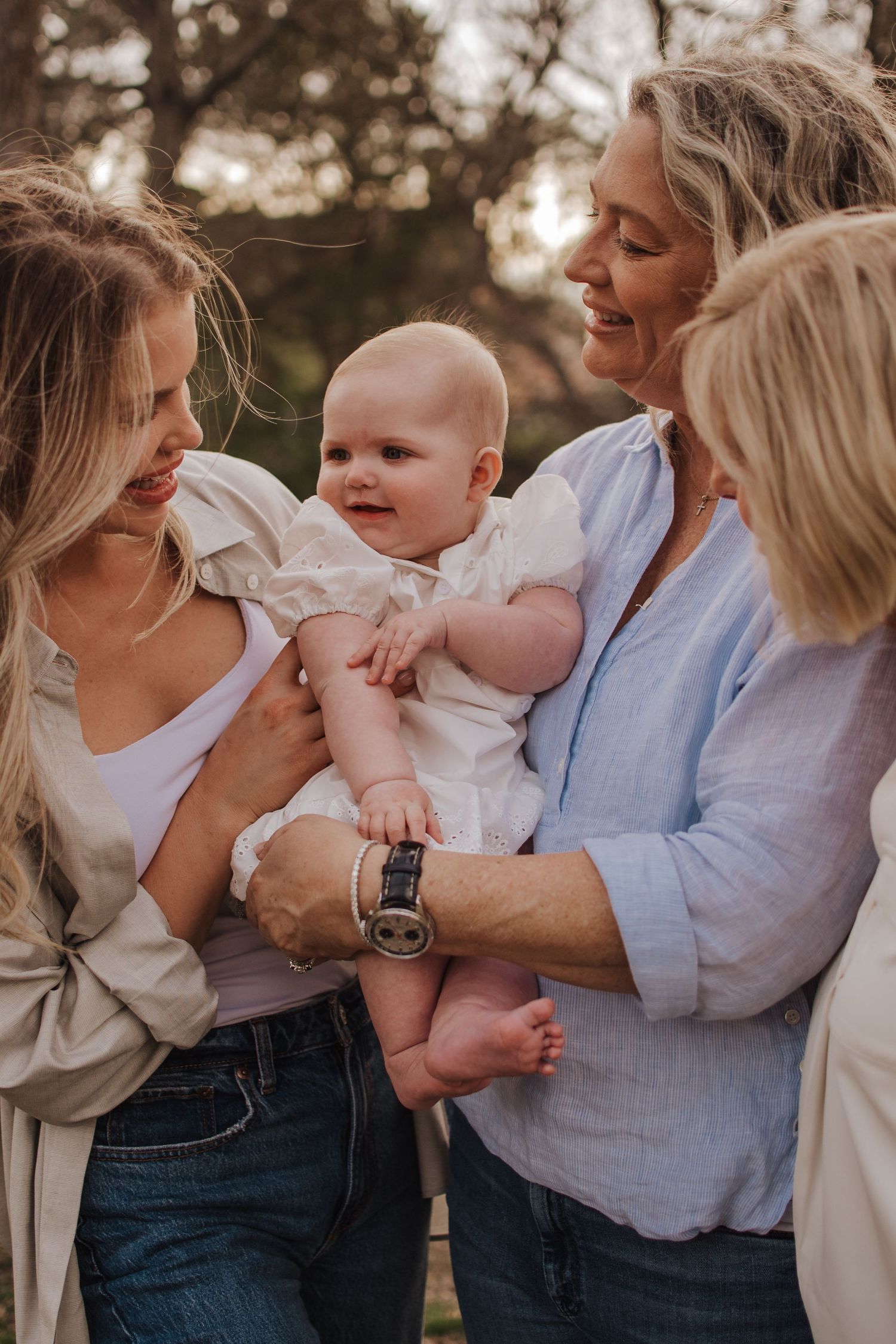 A loving family shares joyful moments together outdoors during a sunset photo session.