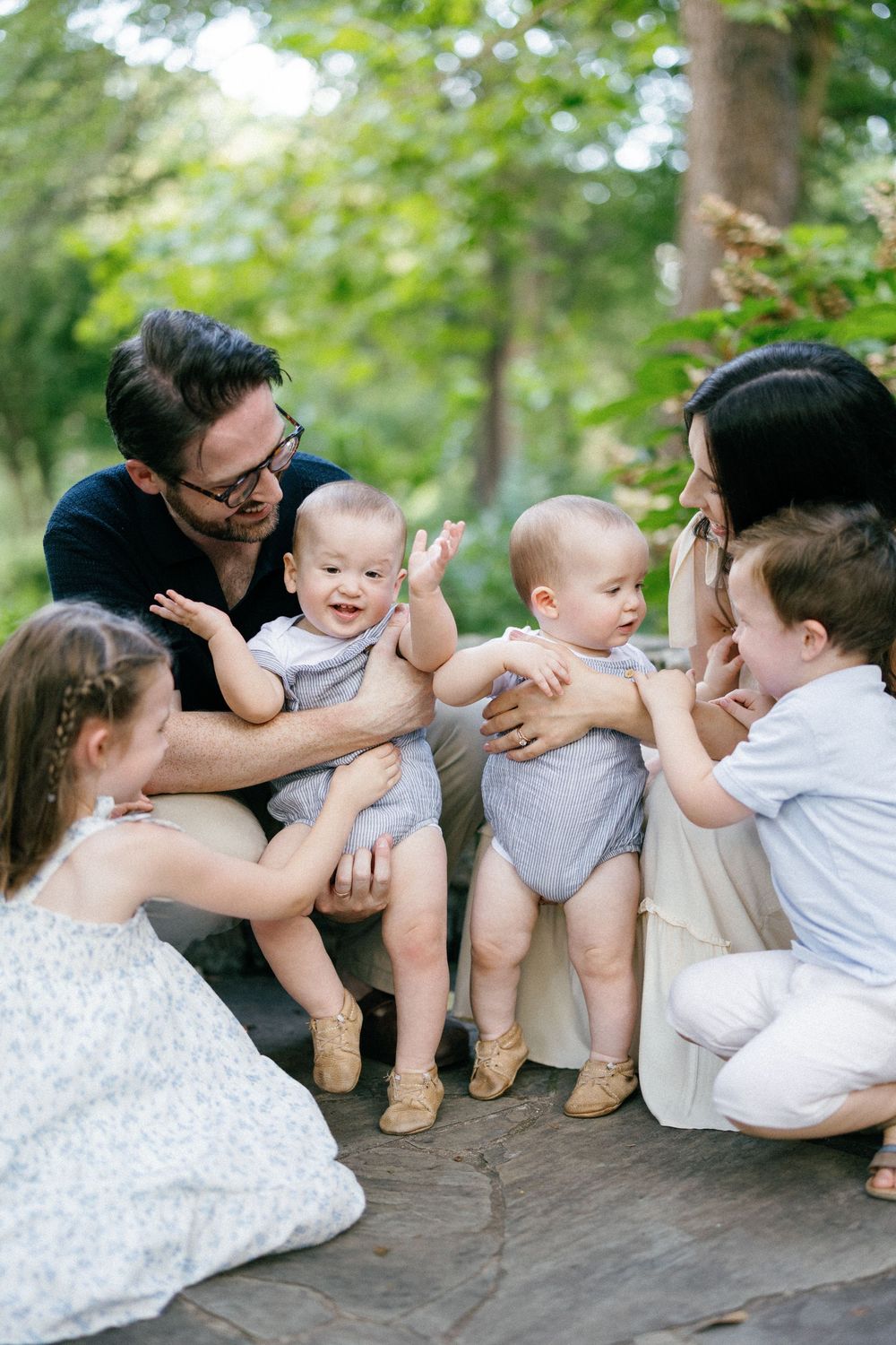Family members share a lighthearted moment together while seated outdoors during a photo session.
