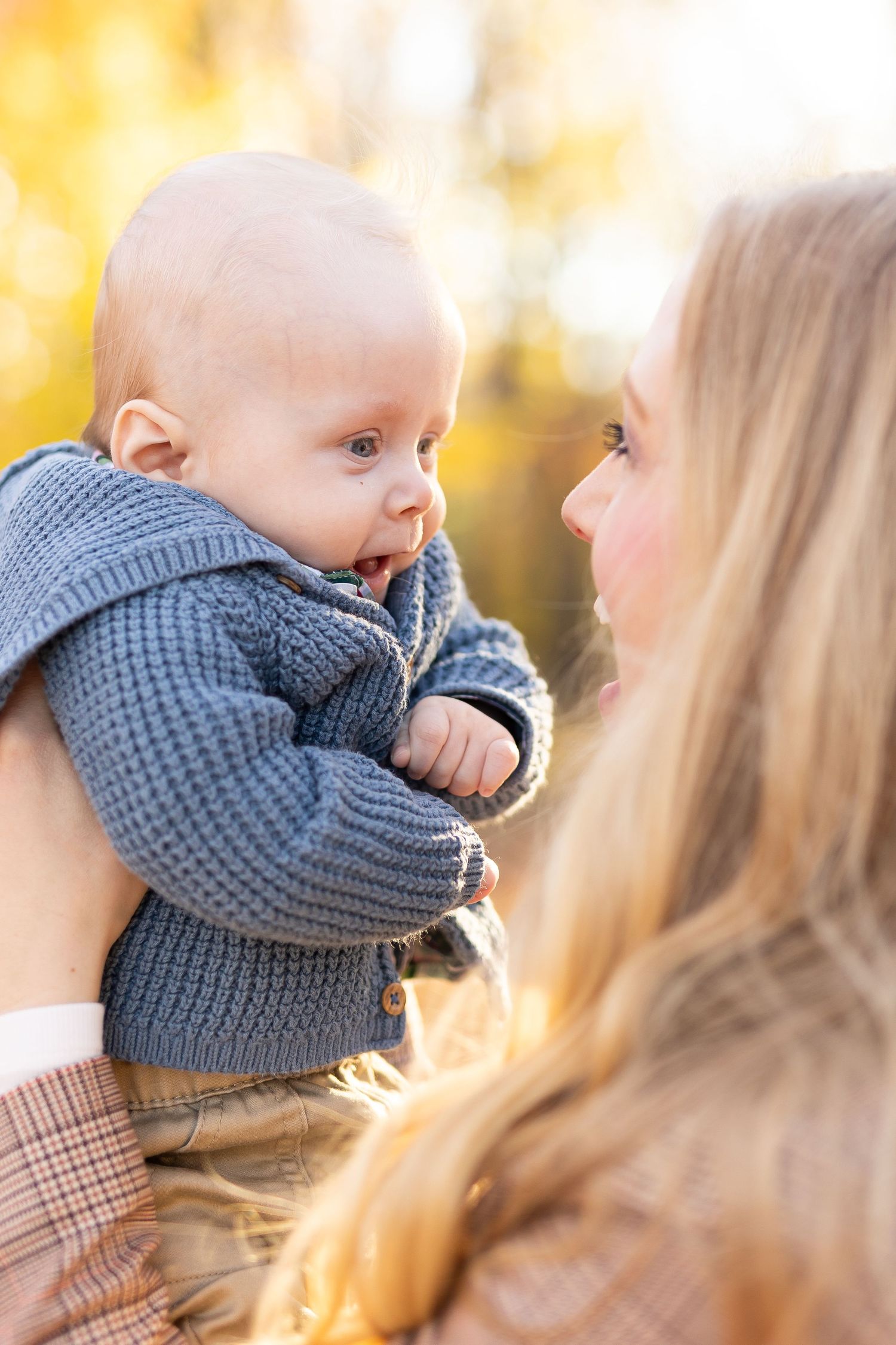 Infant son smiling at his mom during a fall family session