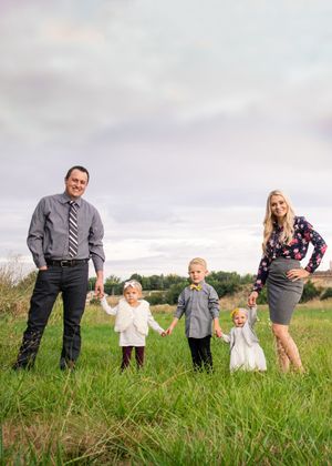 Playful family portrait session in a lush green meadow.