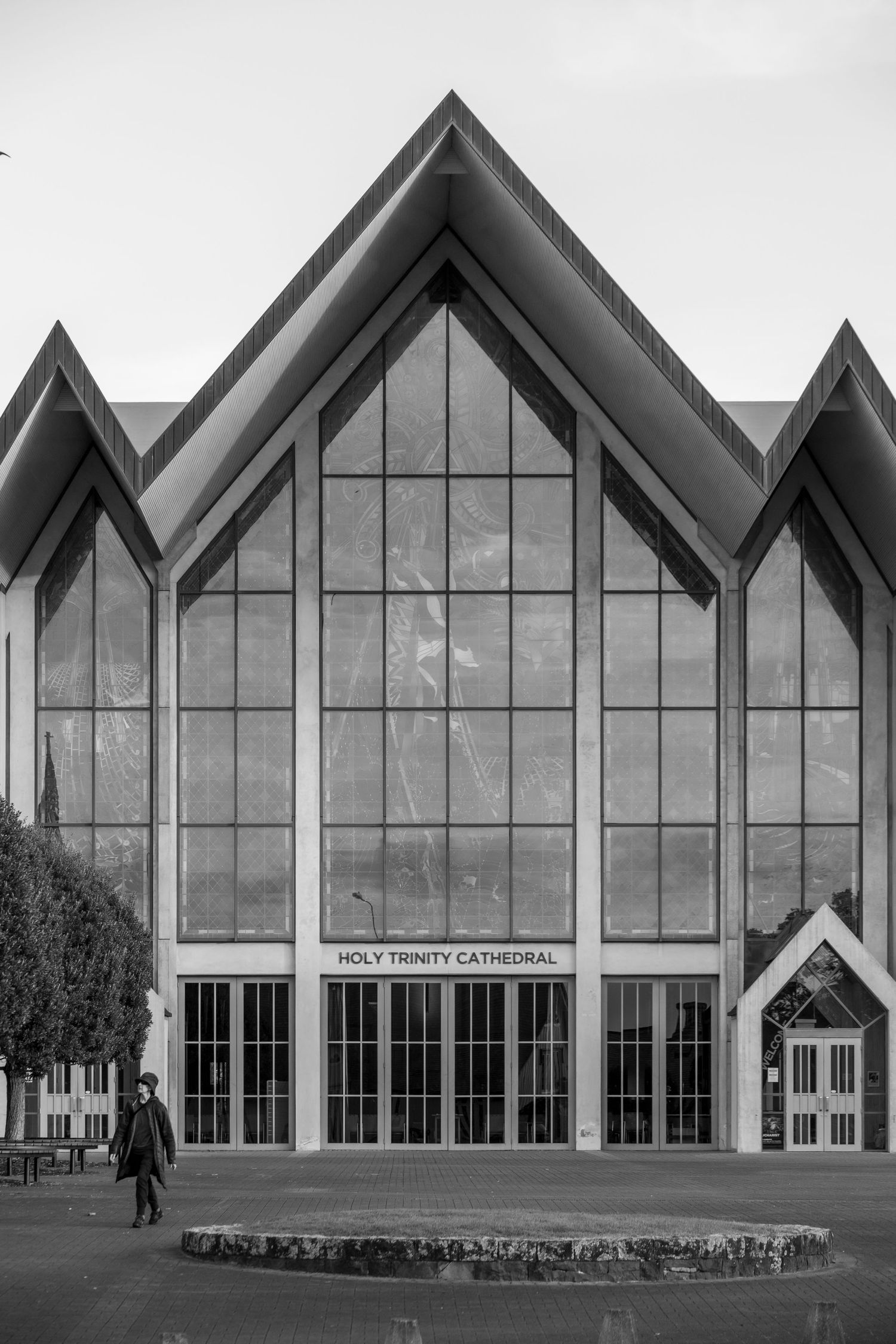 Symmetrical black-and-white photograph of Holy Trinity Cathedral with strong vertical lines and angular roof peaks.