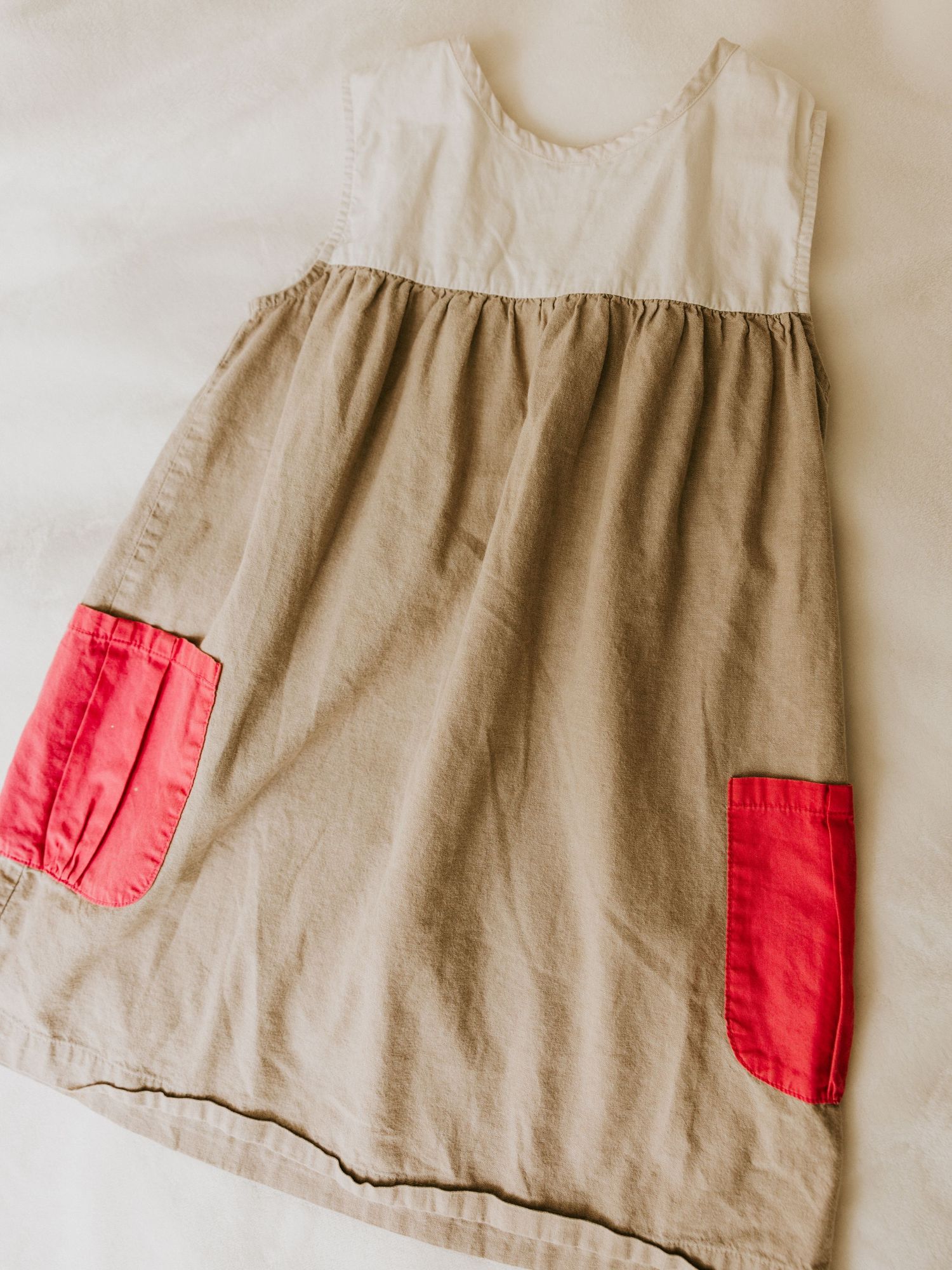 Stylish kids outfit featuring gray button-down shirt with floral bow tie, navy suspenders and khaki shorts.