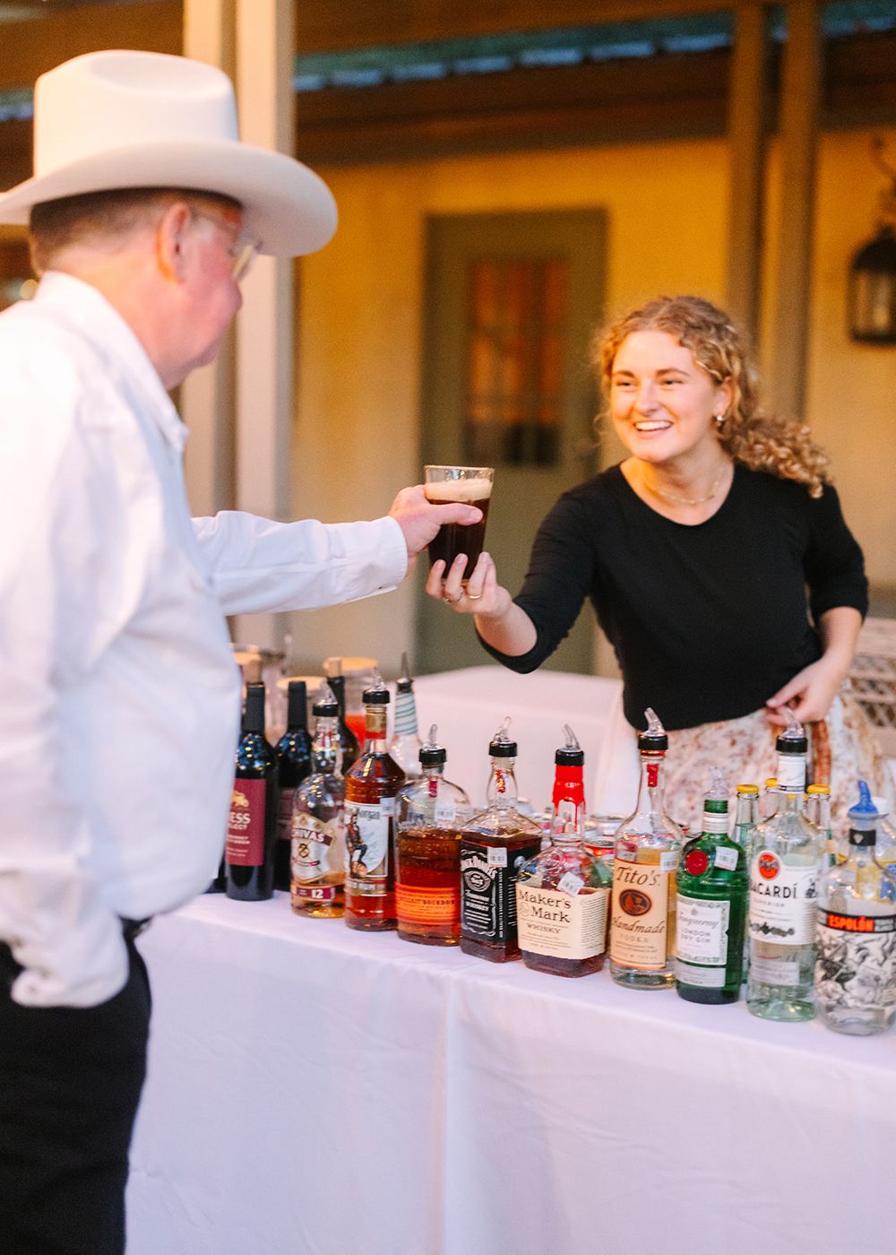 A collection of liquor bottles lined up on a bar counter for a whiskey tasting or spirit sampling event.