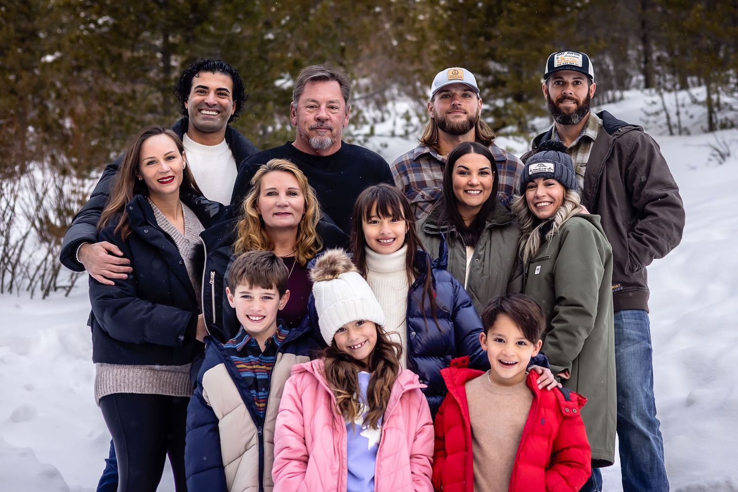 Large family group portrait in winter snow with mix of casual outfits.