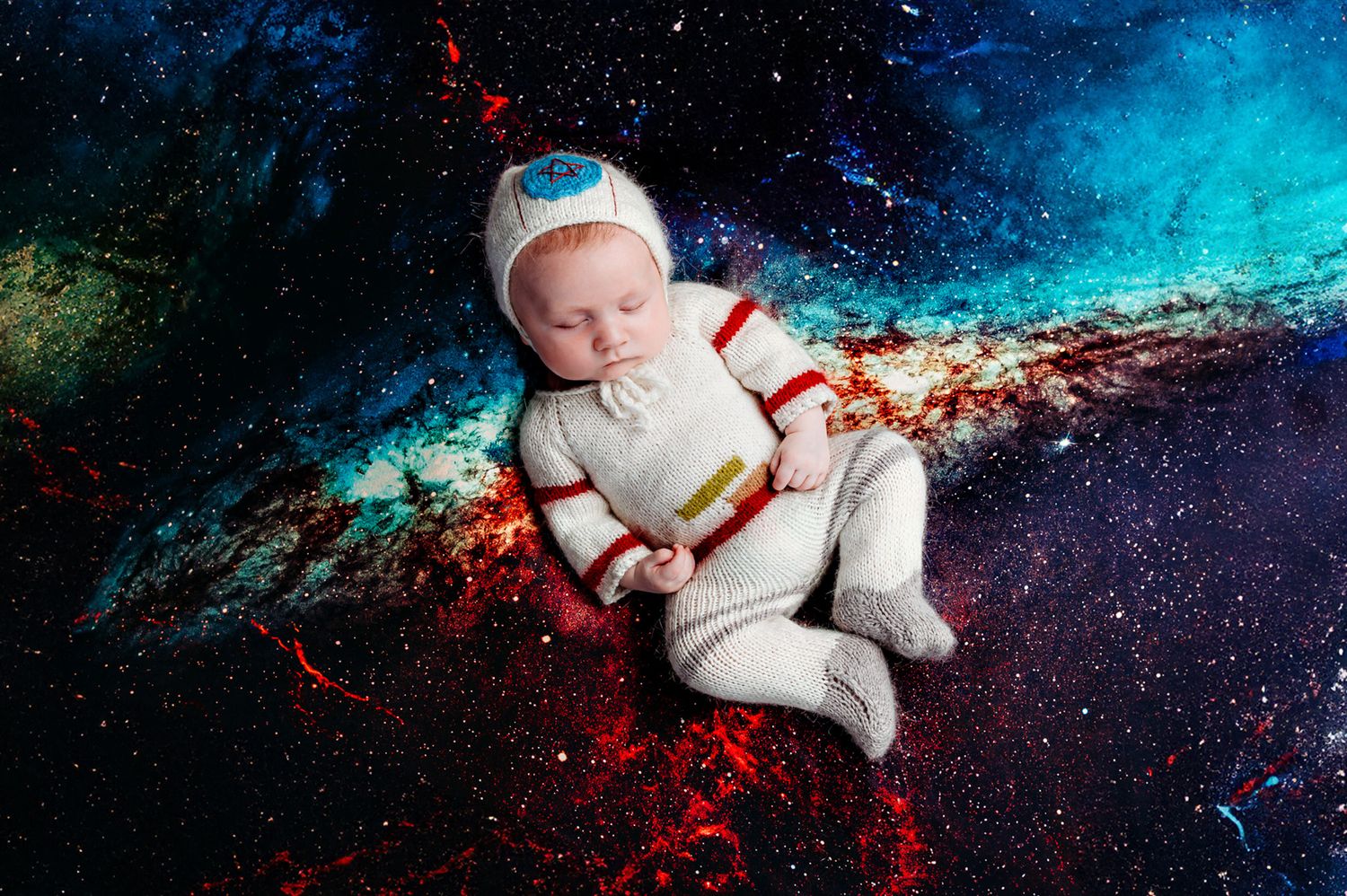Artistic newborn photography against a cosmic blue and red galaxy background.