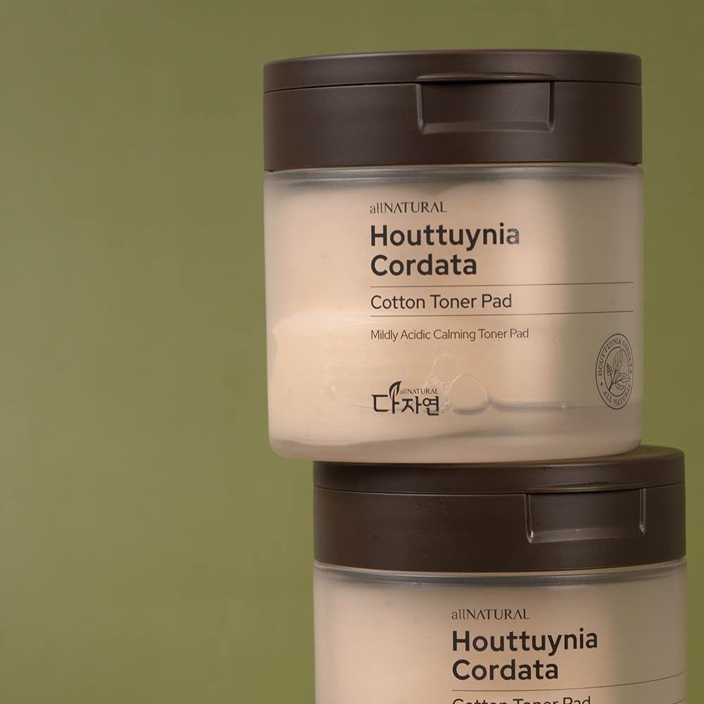 Two stacked jars of Houttuynia Cordata cotton toner pads against a green background.