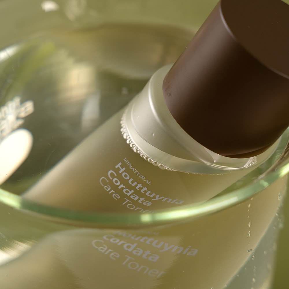 Close-up shot of a skincare product bottle with translucent liquid against a blurred background.