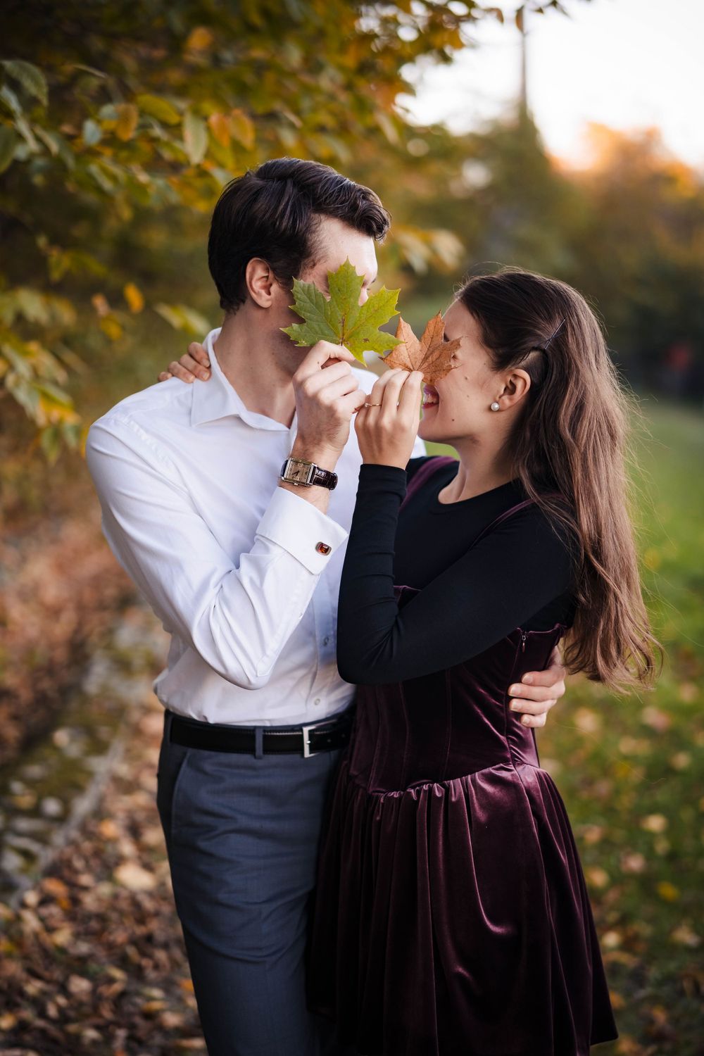 Playful autumn engagement photos with couple drinking from coffee cups.