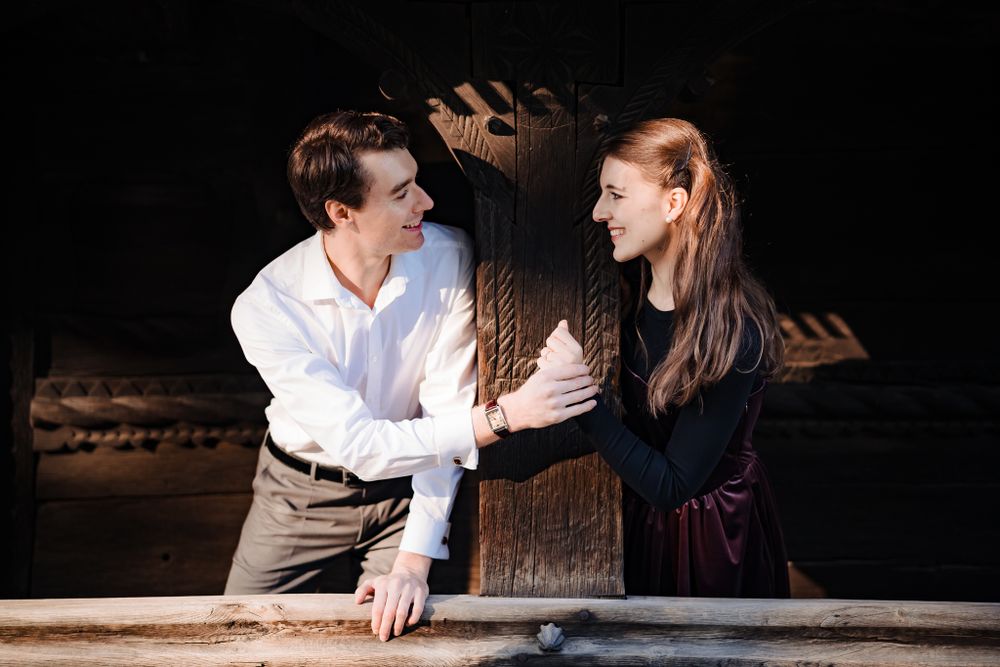 Couple sharing intimate moments in a dark rustic setting with dramatic lighting.
