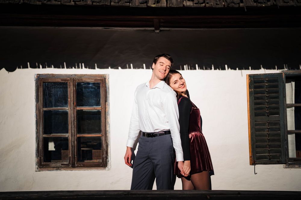 Romantic silhouettes against white wall in vintage architectural setting.