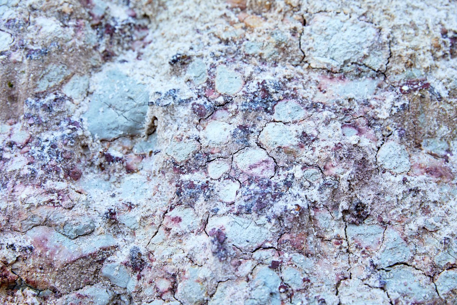 Abstract pattern of weathered rock surface with blue and white mineral deposits.