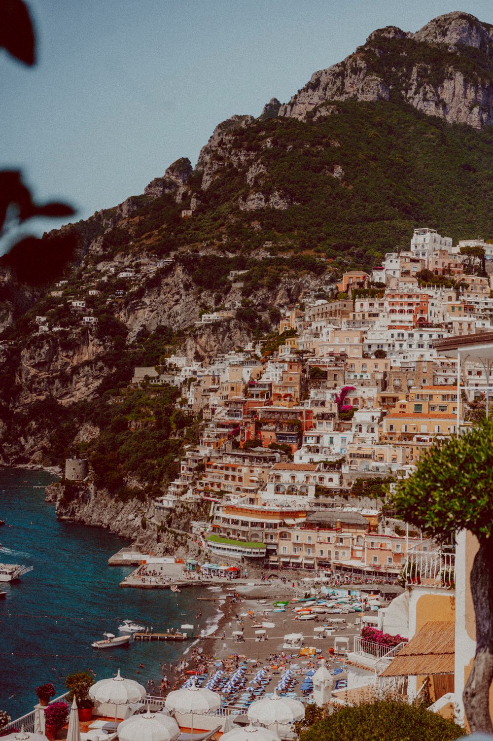 Dramatic coastal view of Positano's colorful buildings stacked along steep cliffs above the Mediterranean.