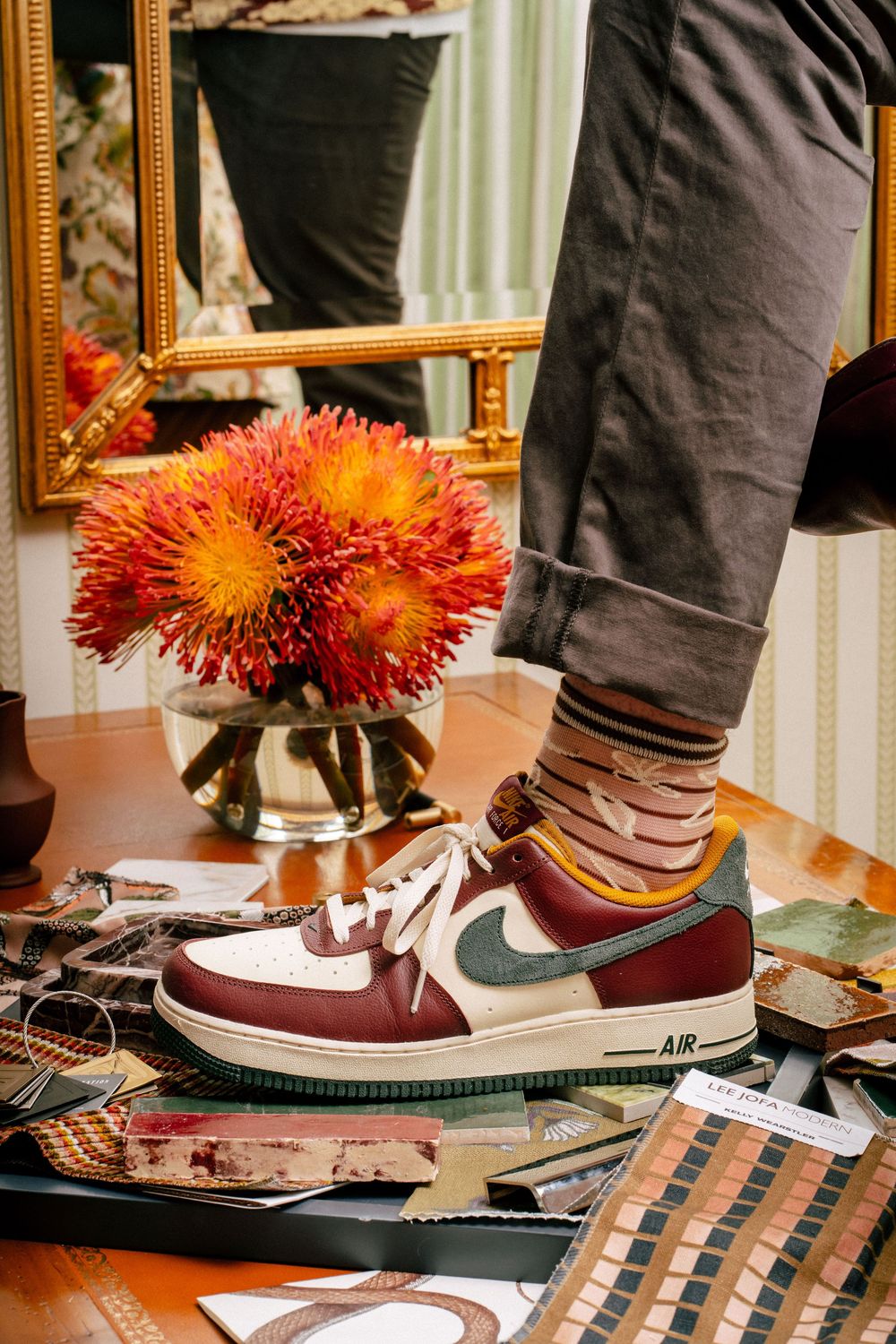 Collection of Nike sneakers arranged on display with orange floral decorations and mirrors in the background.