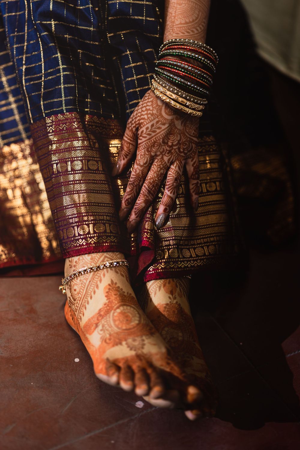 Traditional Indian bridal mehndi adorns hands and feet with bangles and toe rings in rich cultural detail.