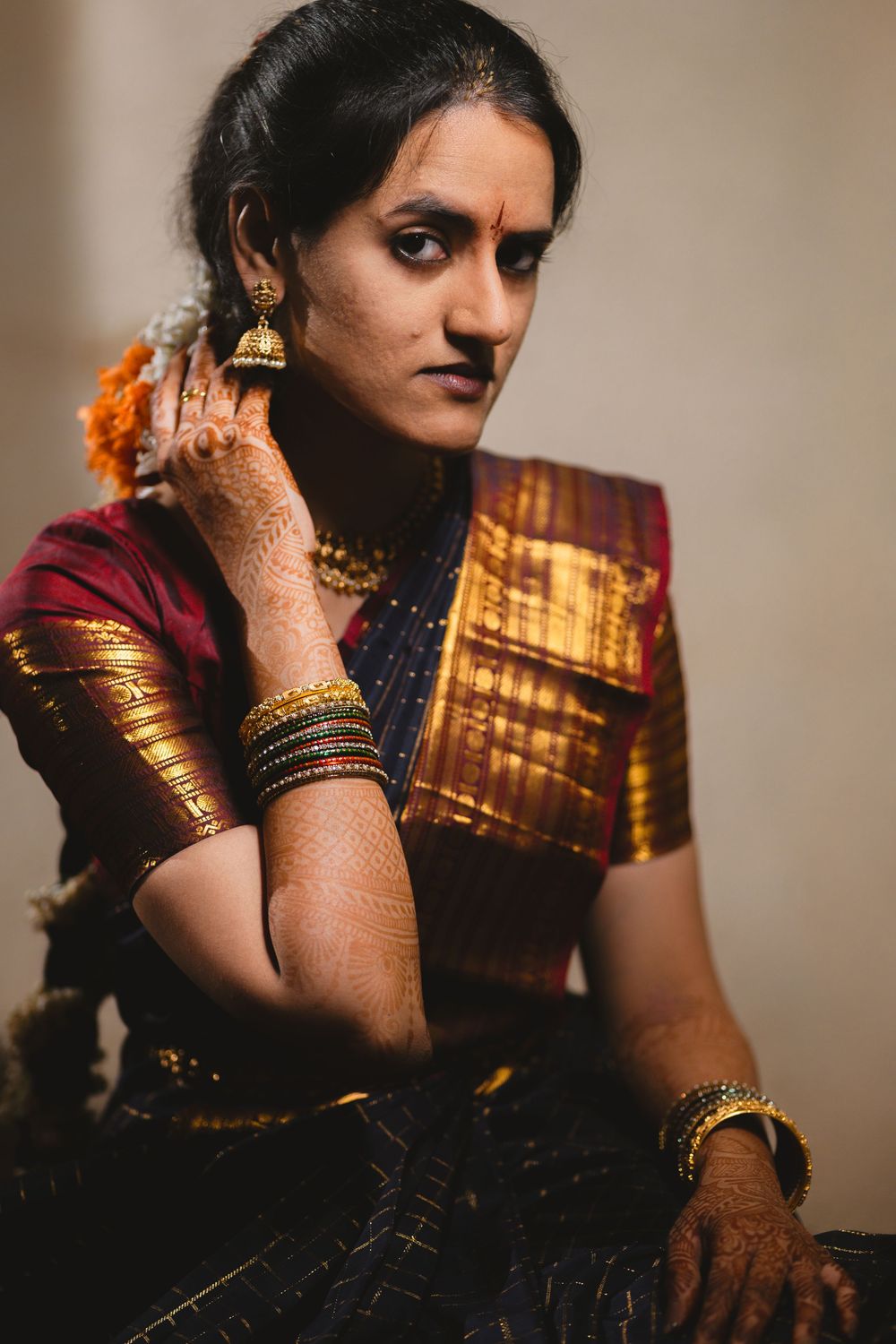A series of artistic portraits showing traditional Indian bridal jewelry and henna adorned hands in moody lighting.