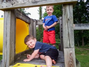 Children playing on yellow playground structure outdoors.