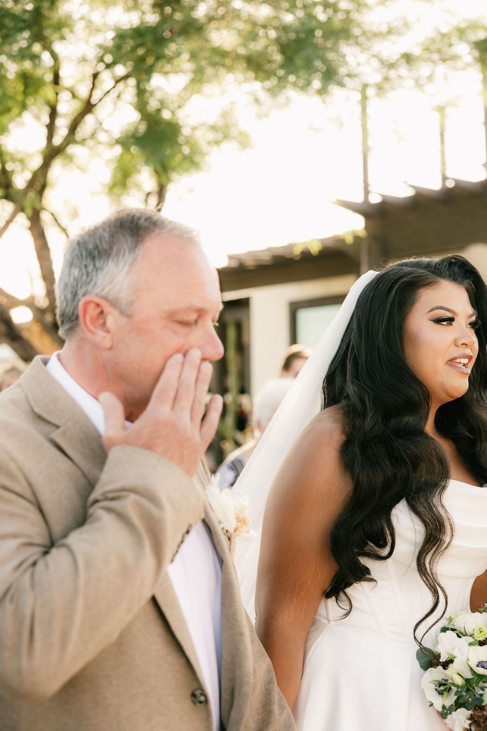 Emotional wedding moment captured during outdoor ceremony with desert backdrop.