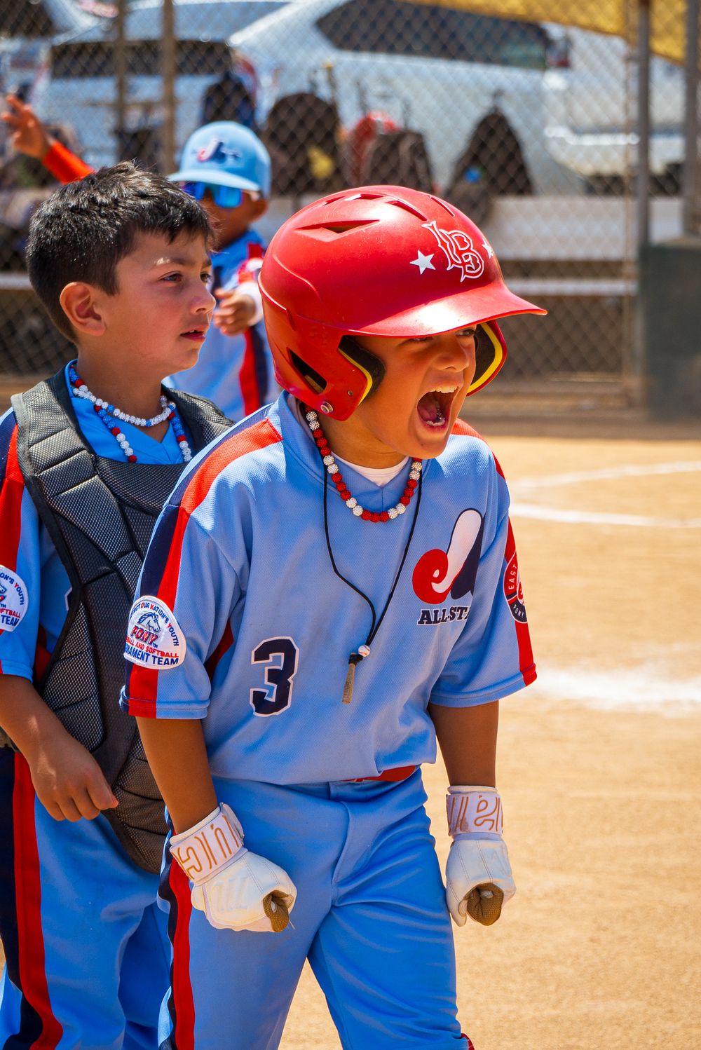 Baseball team members in light blue uniforms cheer together during game.