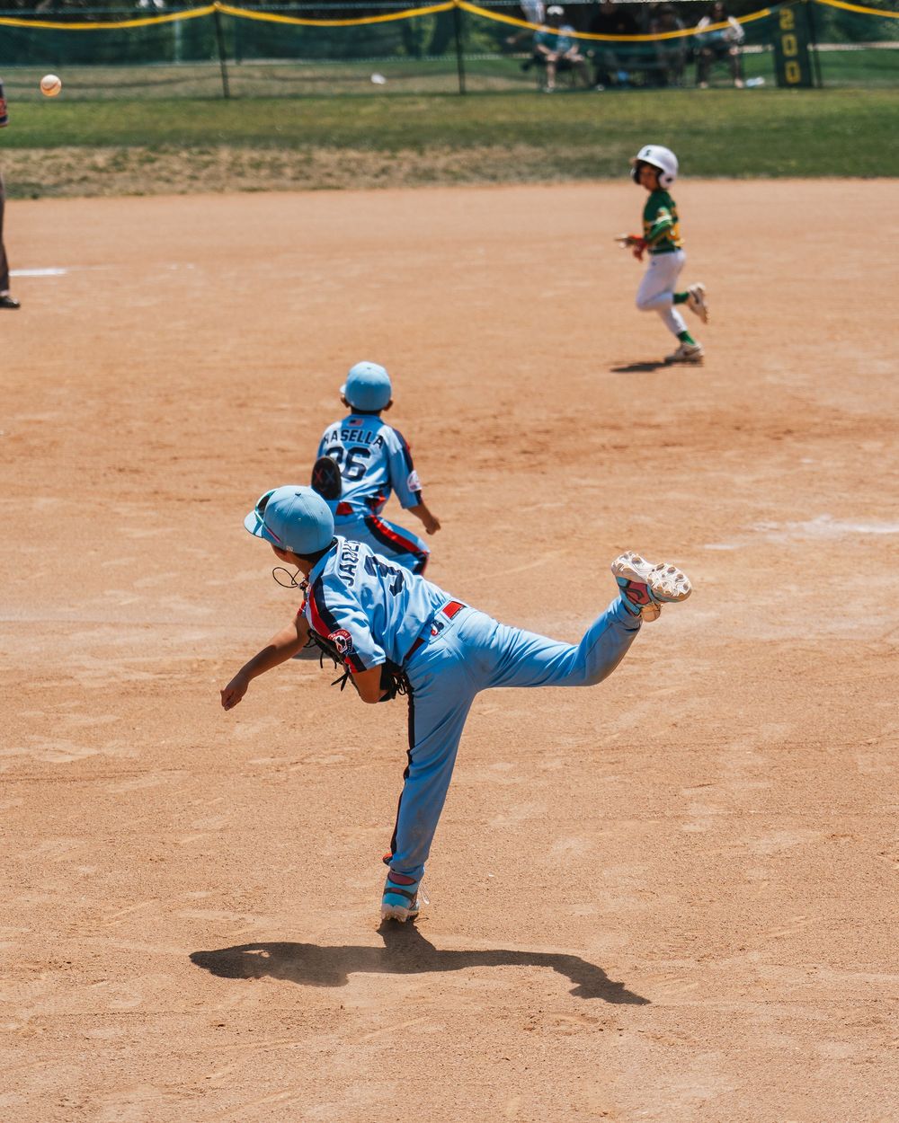 Baseball player practicing pitching form in sequence on dirt field.