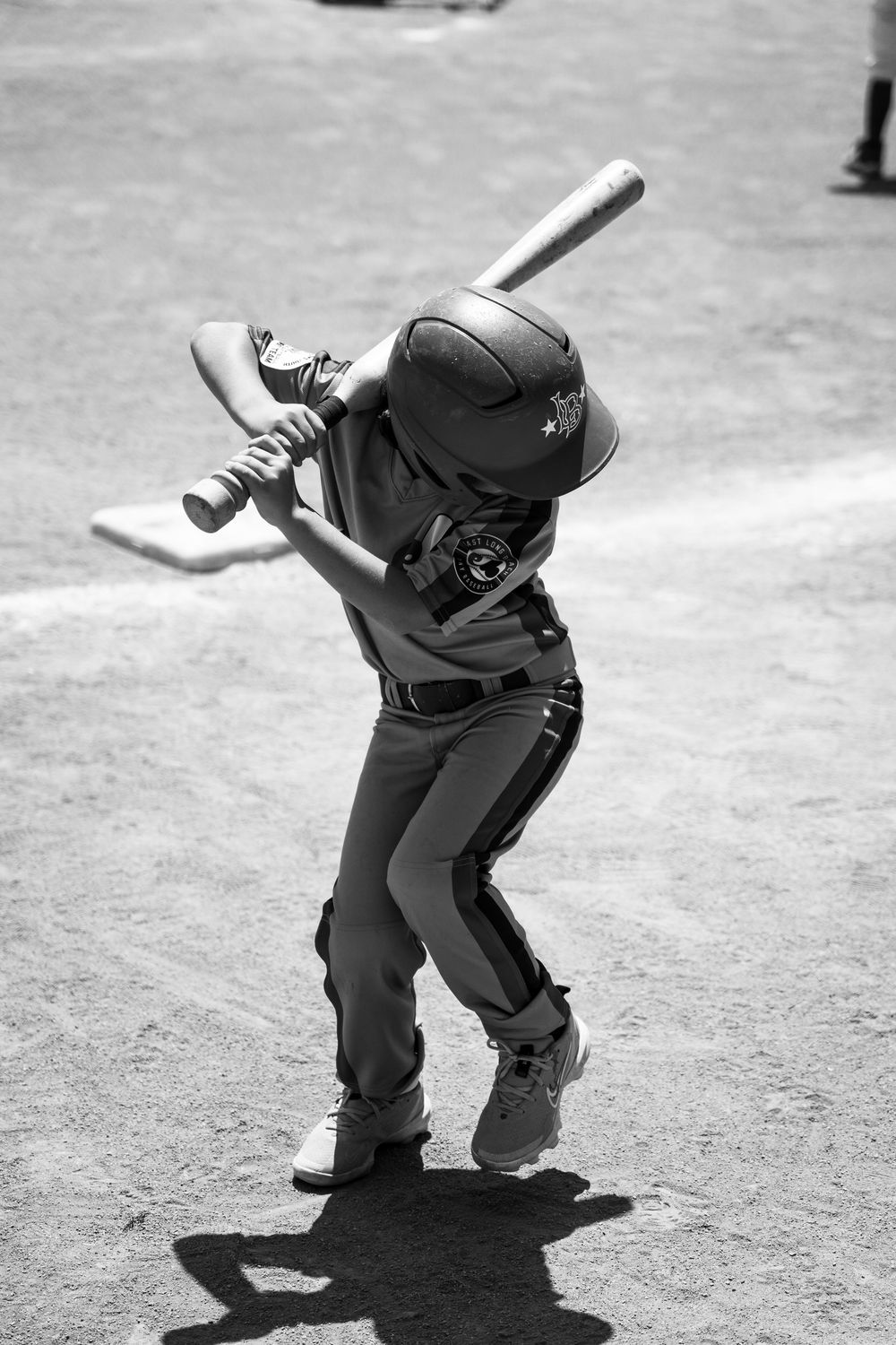 Black and white photo of baseball player demonstrating batting stance.