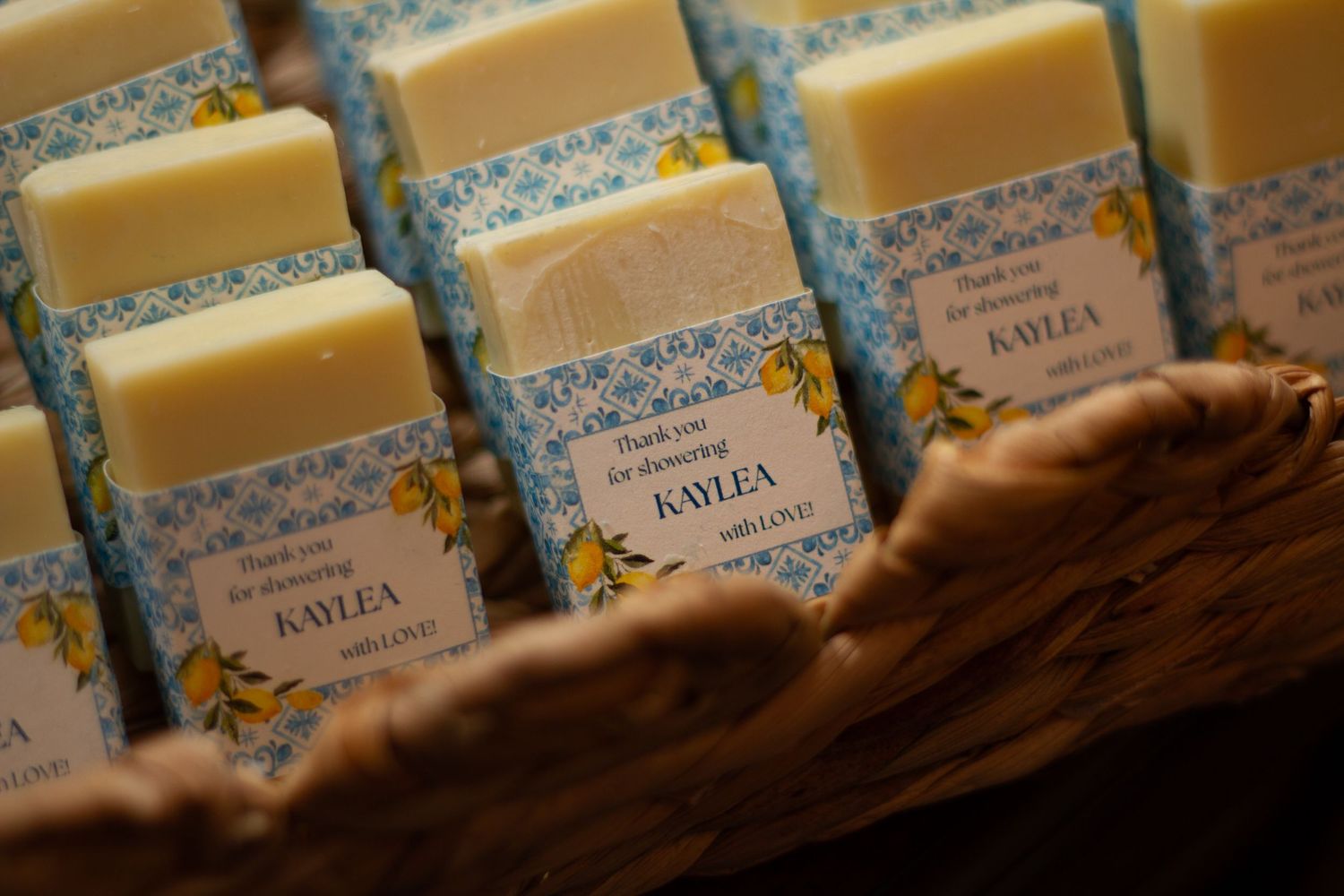 Rows of handmade artisanal soap bars with vintage blue and white labels displayed at a craft market.