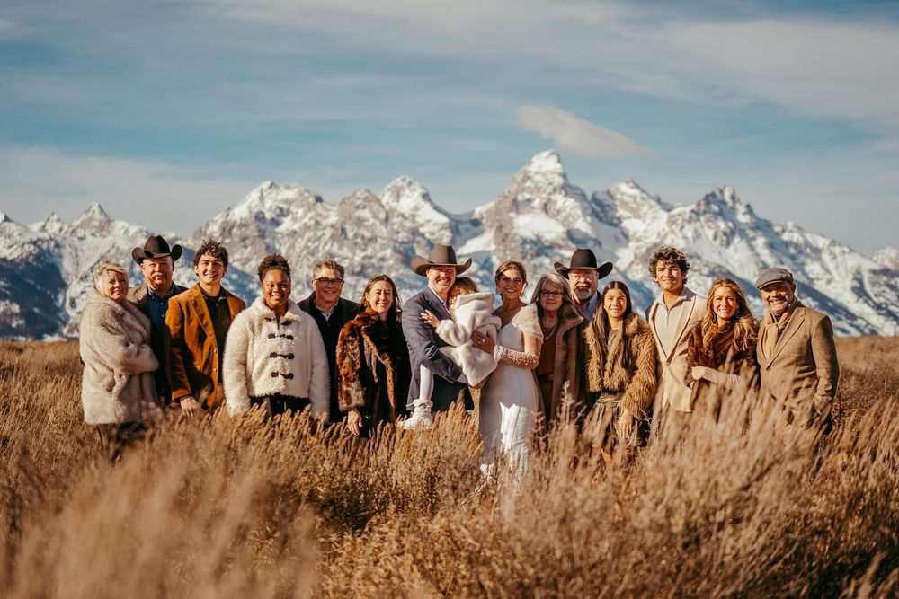 Romantic winter mountain wedding portrait of a bride and groom in a snowy landscape at golden hour.