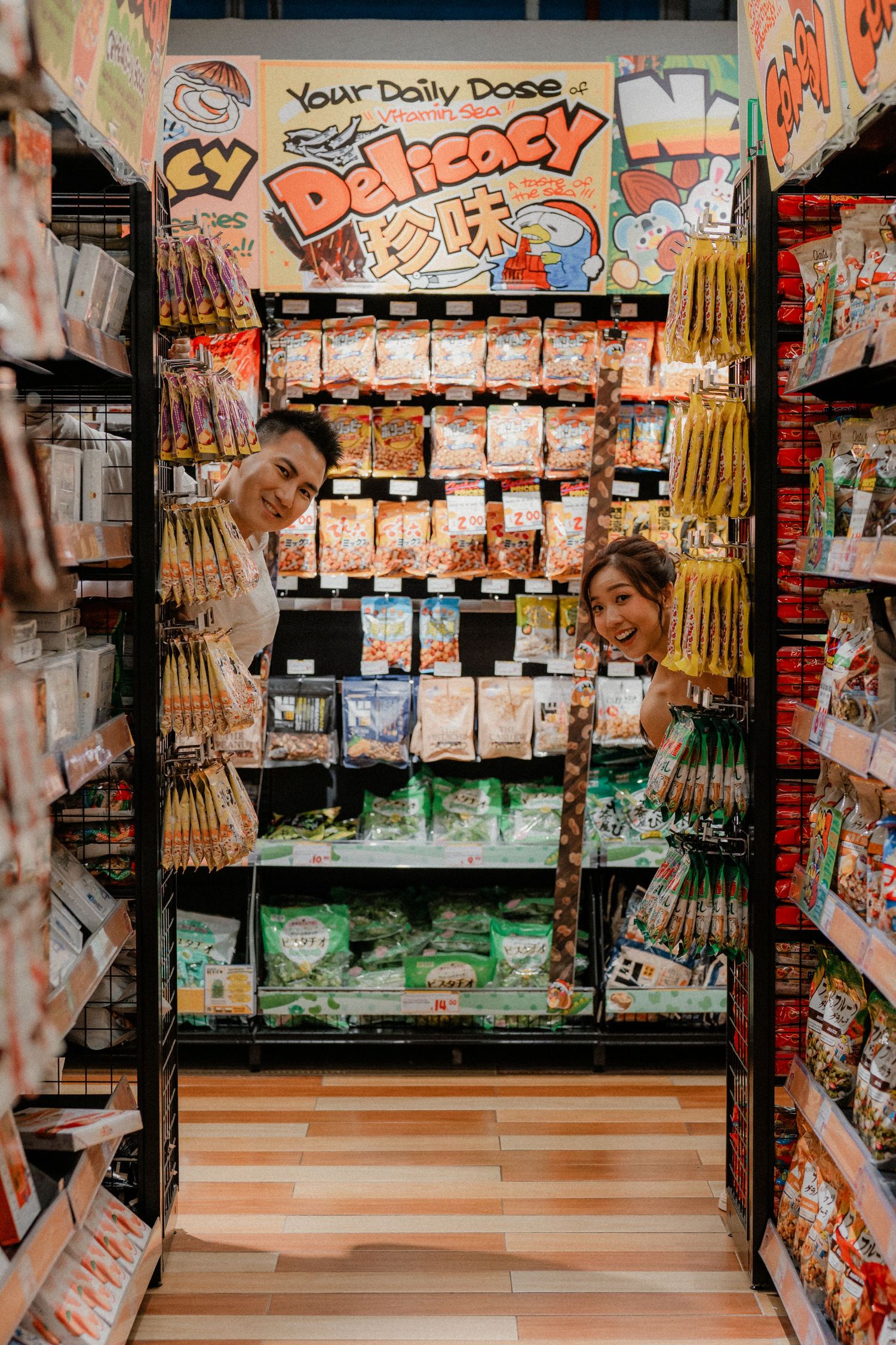 Wide shot of supermarket snack aisle with Japanese food products and displays.