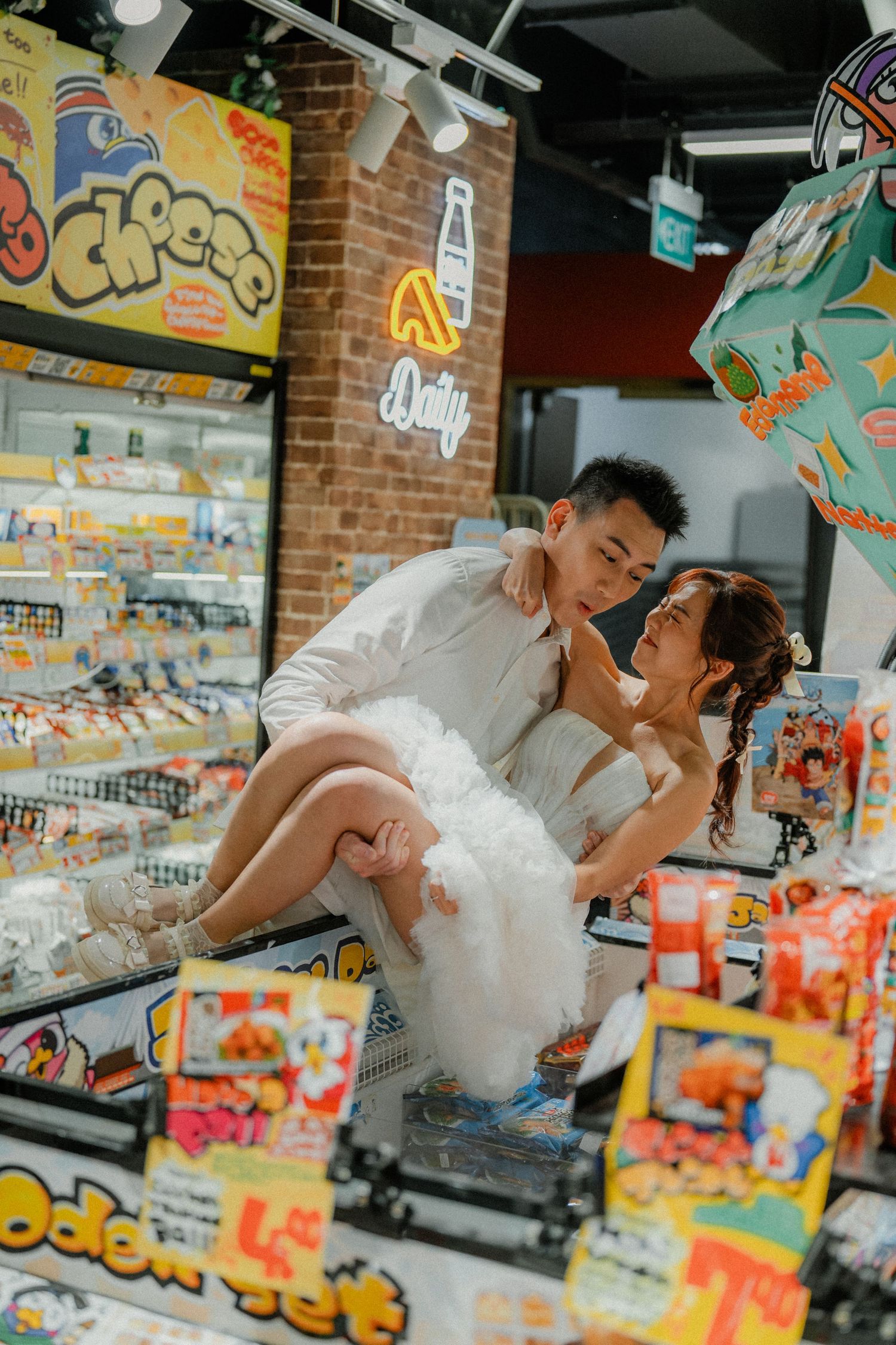 Romantic pose between grocery store aisles with couple in elegant white attire.