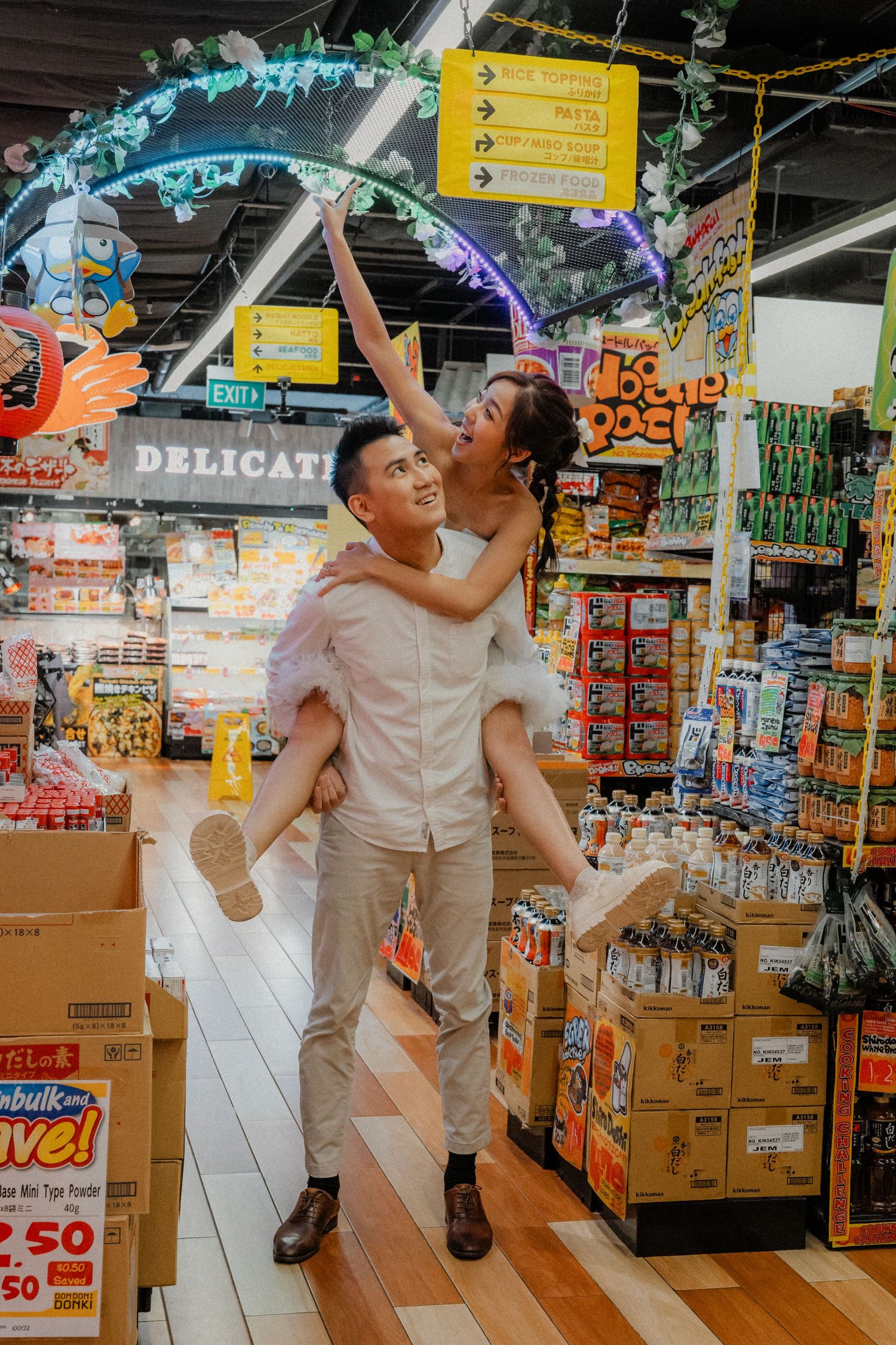 Playful piggyback moment under decorated archway in grocery store.