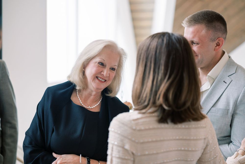 People engaged in a professional conversation in an office setting with natural lighting.