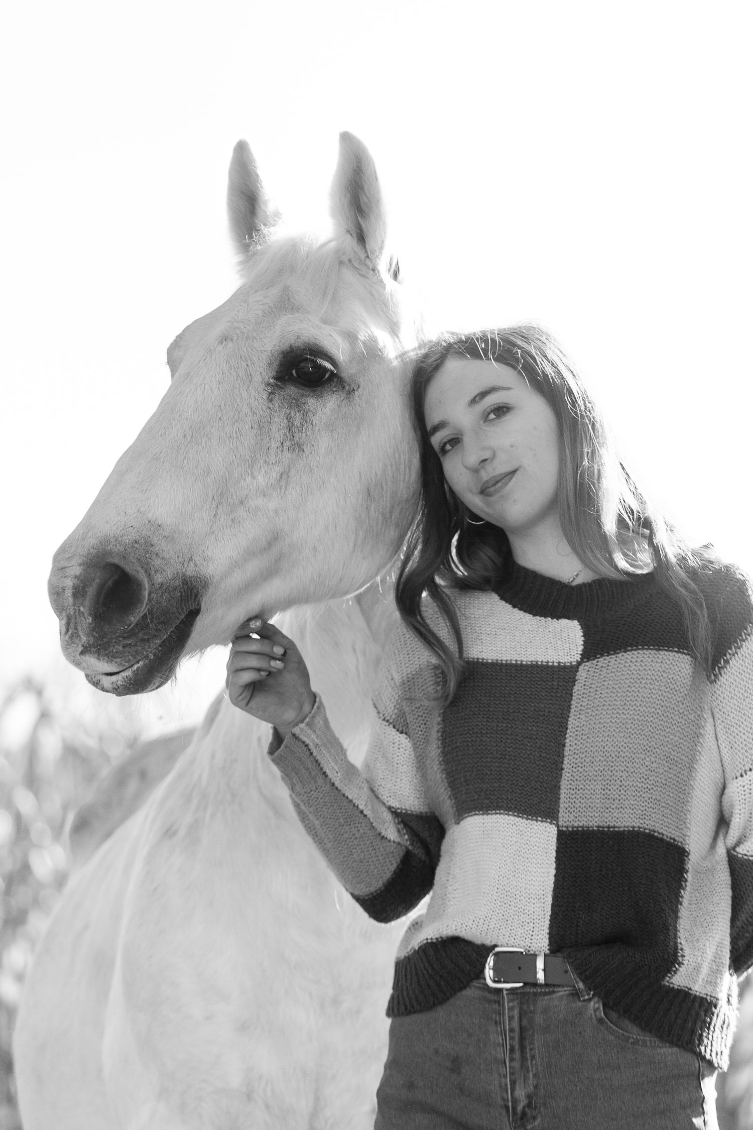 A series of intimate black and white portraits showing a person with a white horse against a light background.