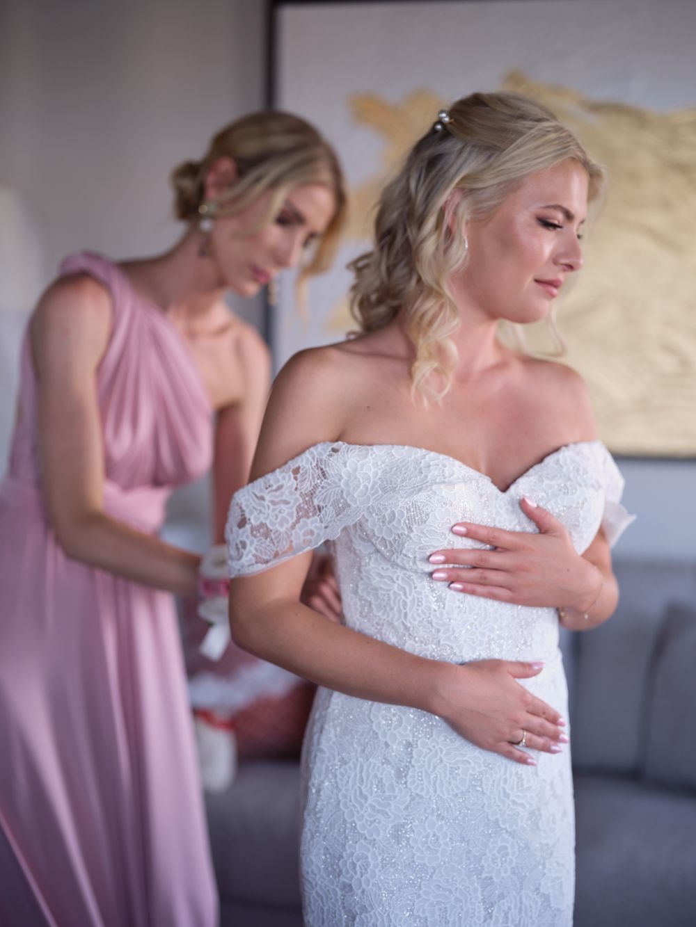 Close-up shots of a white lace wedding dress being adjusted during bridal preparations. Photoshoot by Venice Photographer Alina Indi