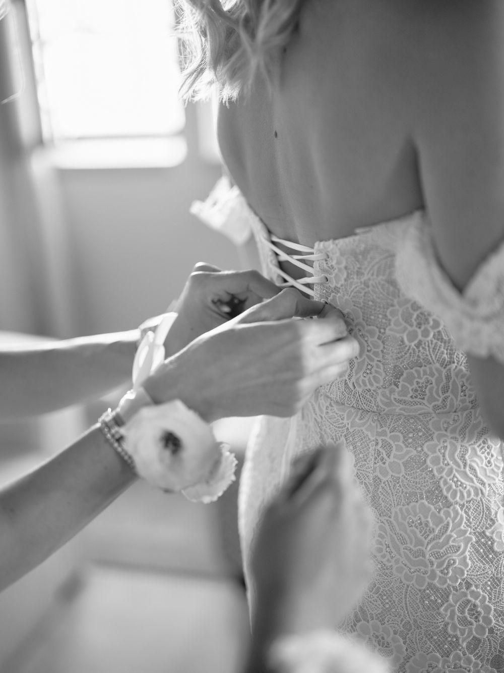 Detail shots of intricate lace being adjusted on a white wedding gown. Photoshoot by Venice Photographer Alina Indi