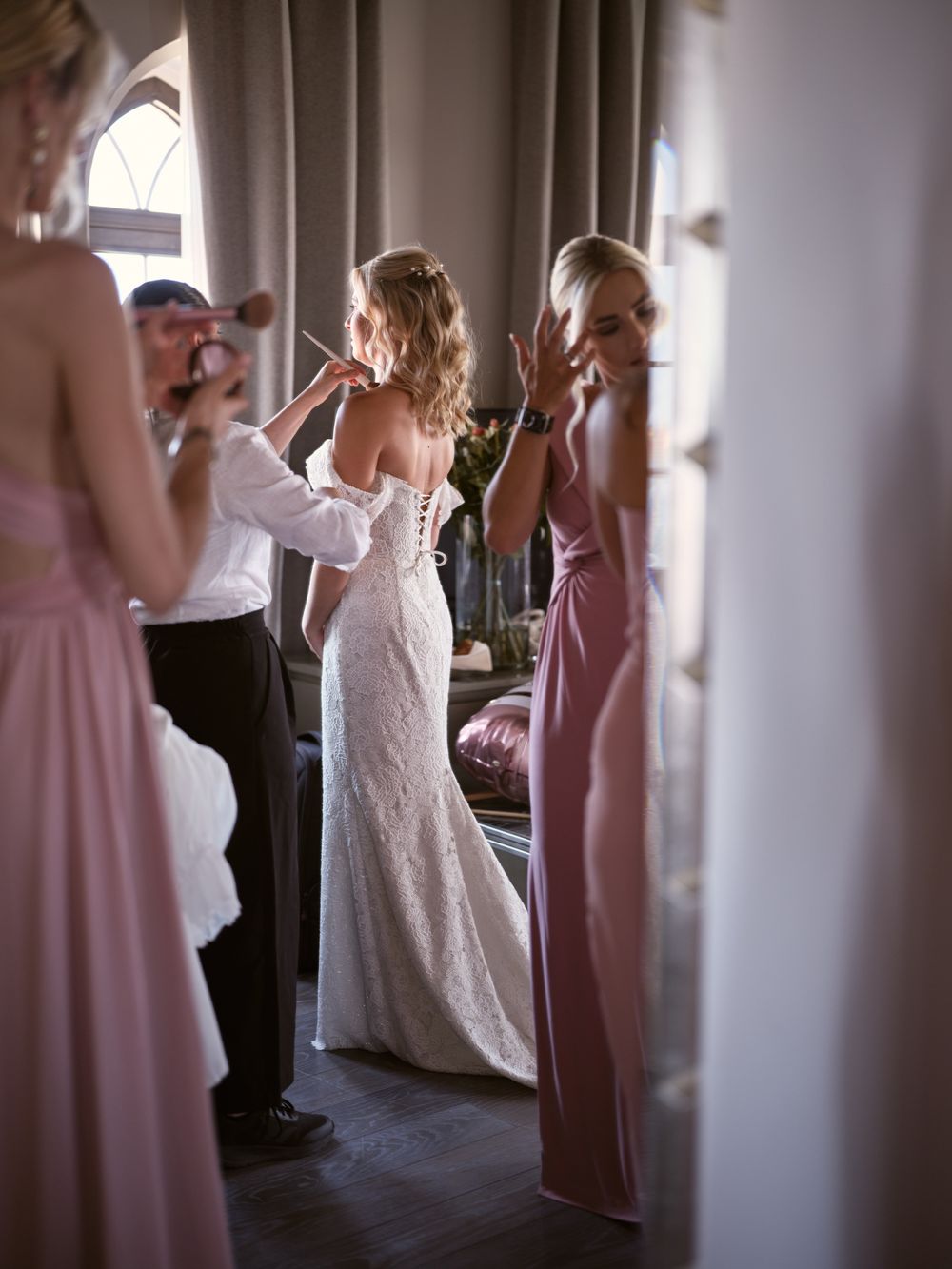 Wedding party members in pink dresses dance and celebrate in an elegant indoor venue. Photoshoot by Venice Photographer Alina Indi