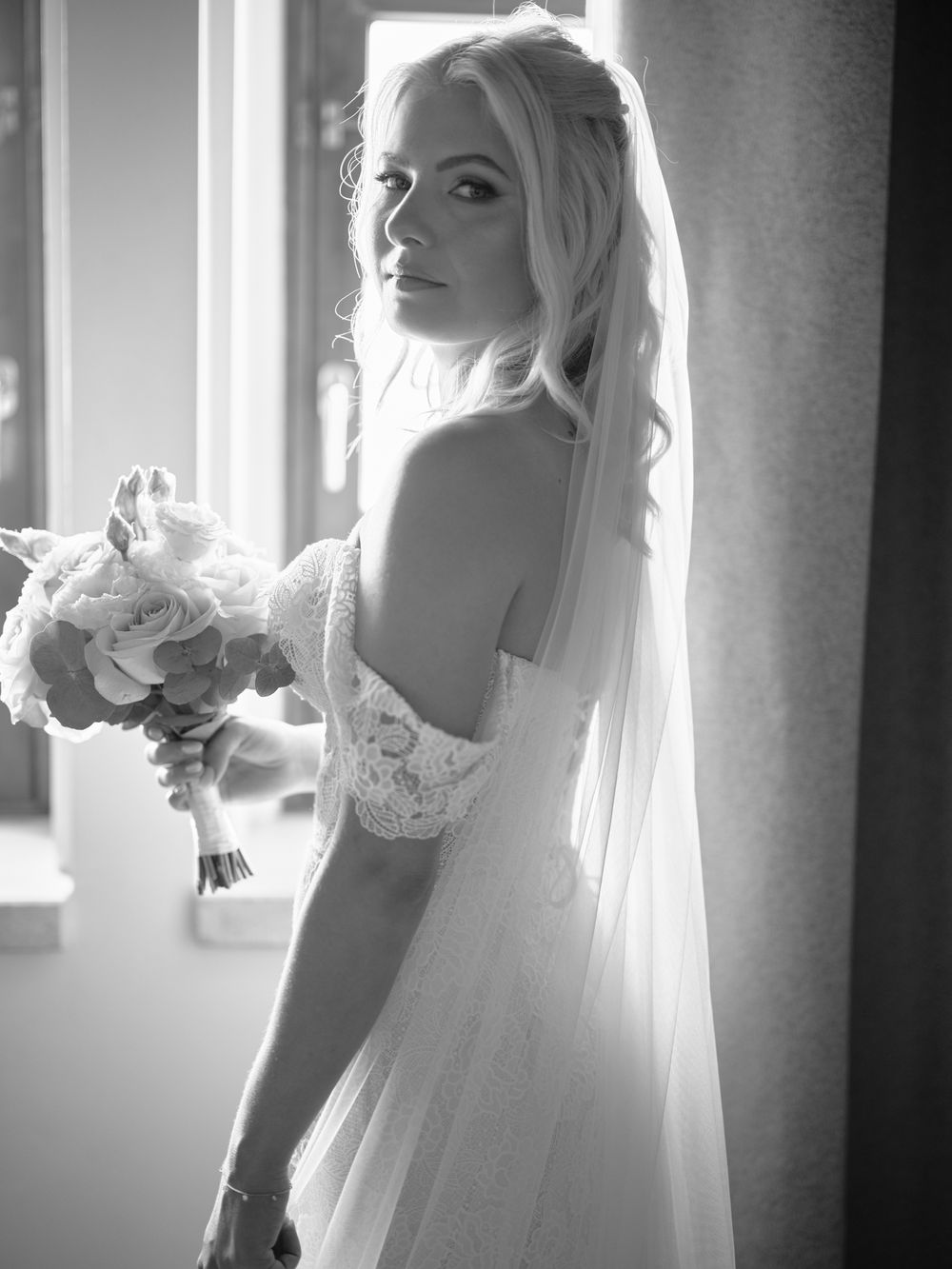 Ethereal bridal portraits with soft window light highlighting a flowing white veil. Photoshoot by Venice Photographer Alina Indi