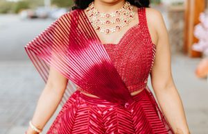 Close-up of bright red striped dress with pleated tulle overlay and embellished sweetheart neckline.