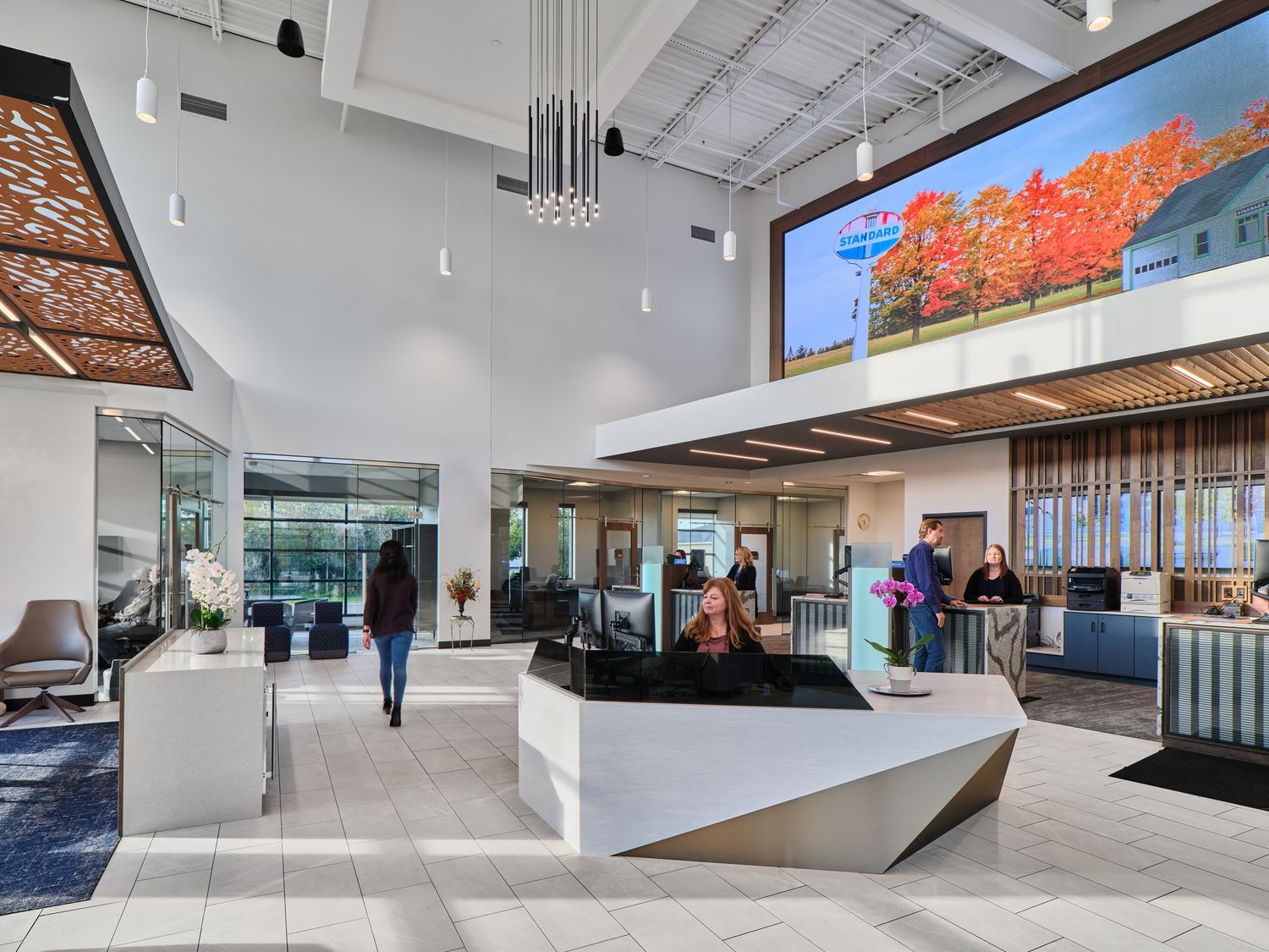 Contemporary bank office lobby with high ceilings, modern furnishings, and digital displays.