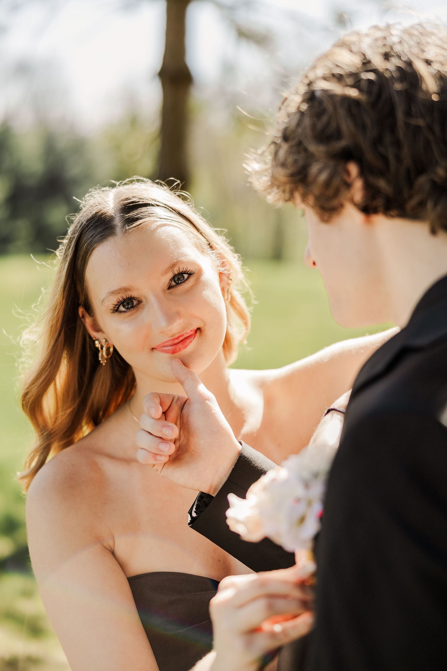 Couple shares tender moments in golden sunlight during a romantic outdoor photoshoot.