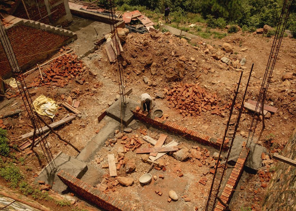 Construction site with exposed bricks and building materials scattered across multiple frames.