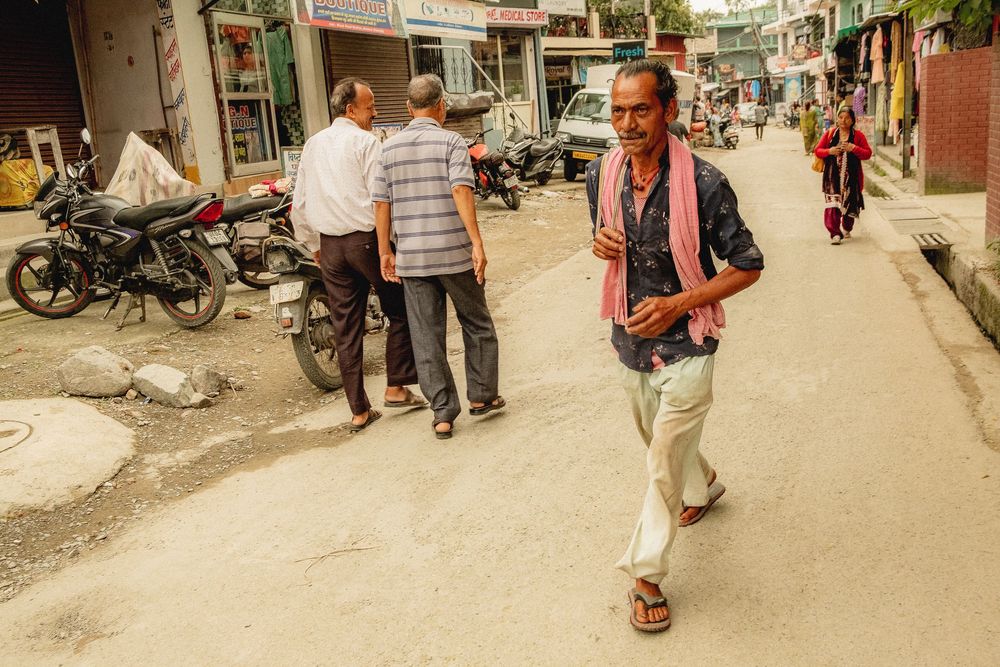 Panoramic view of a busy street with pedestrians and storefronts.