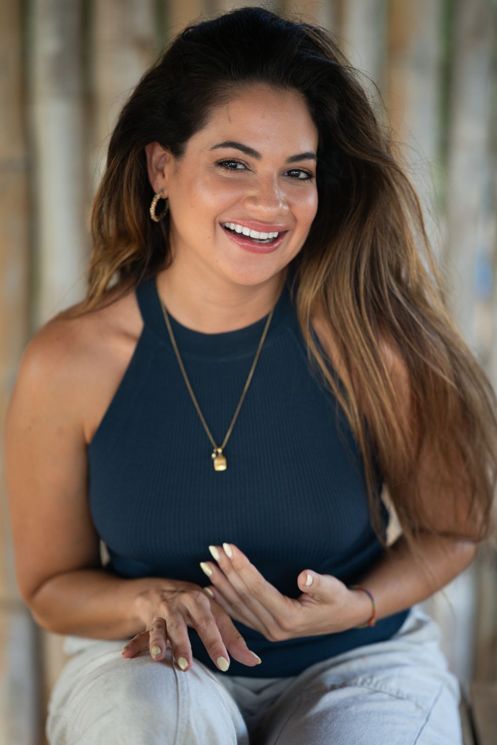 Woman in a navy sleeveless top poses playfully in a series of casual portraits against a light background.