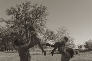Artistic black and white landscape featuring family silhouettes against a dreamy sky.