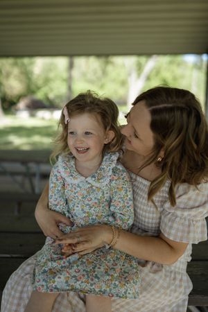 A heartwarming display of family love captured on a park bench in natural lighting.
