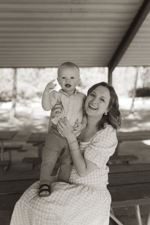 Black and white portrait series capturing tender moments between parent and infant in natural lighting.