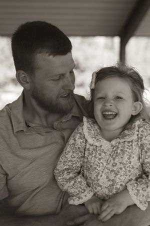 Candid black and white photos showing intimate moments of laughter and bonding between parent and child.