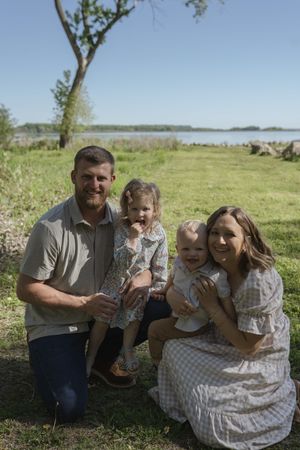 Candid outdoor family photos showing playful interactions in a natural setting with grass and trees.