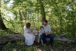 A family gathering in a lush green forest setting with natural lighting.