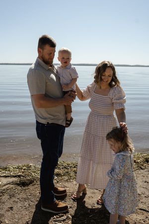 A tender family moment captured on a bright day by the waterfront.