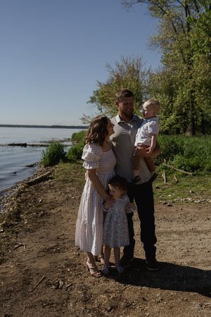 A family enjoying a spring day together on a natural shoreline path.