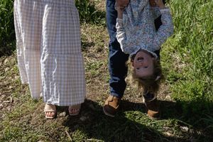 Feet and legs of people standing together on grass in springtime.